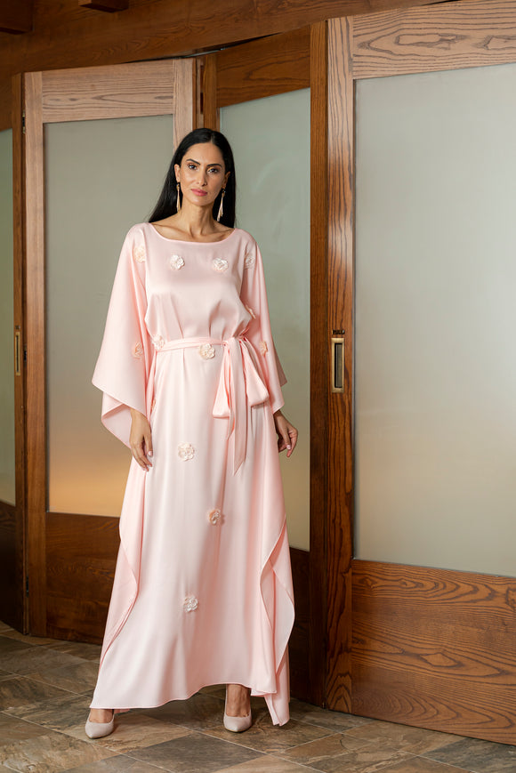 Update your modest-wear wardrobe with embellished kaftan made from silk crepe blended fabric which will offer you chic appeal for majlis nights. This kaftan style has floor skimming silhouette and a sophisticated round neckline. Decorated with 3D organza flowers, this kaftan comes with removable belt, making it perfect ensemble for evening gatherings.